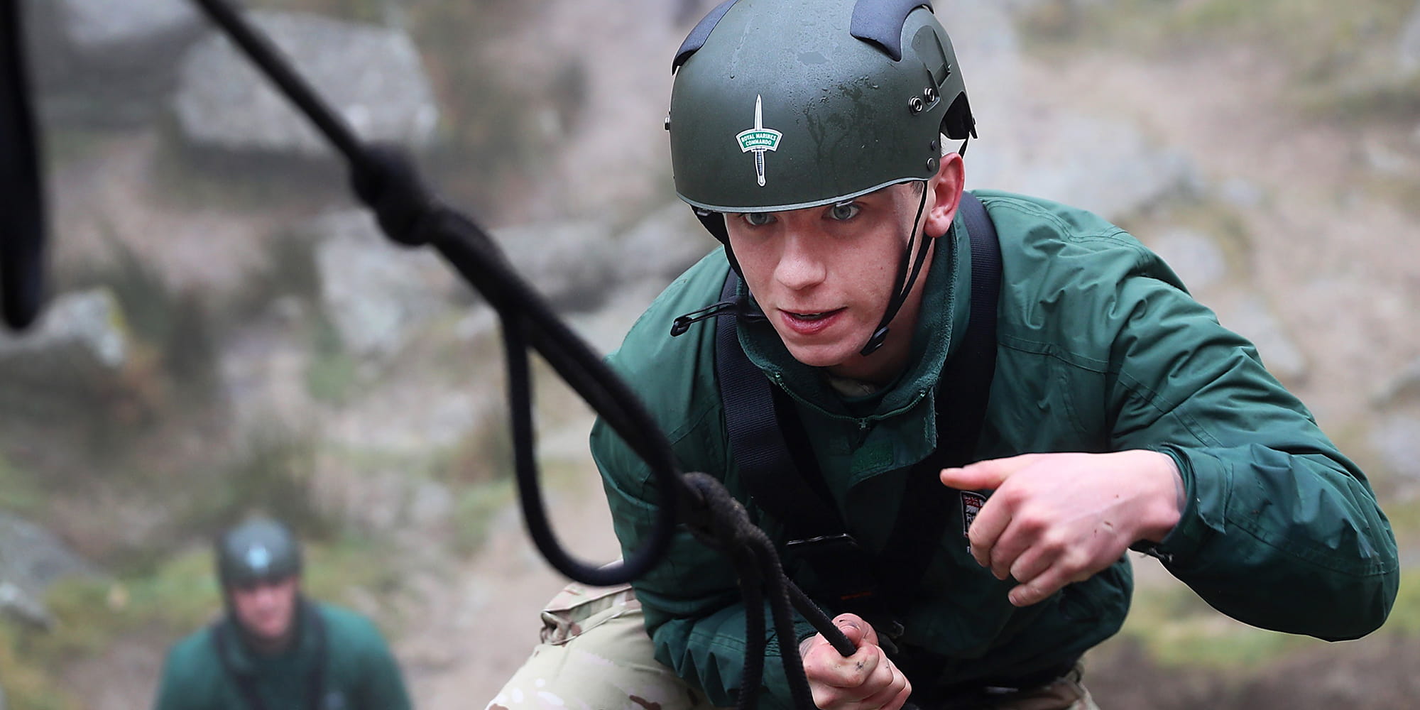 Royal-Navy-Bases-and-Stations-Lympstone-02-base Royal Marine carrying out climbing training wearing green helmet