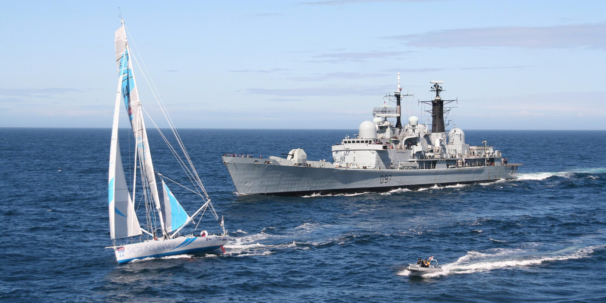 A Duke class frigate, a sailing boat and a small patrol boat sail past the camera.