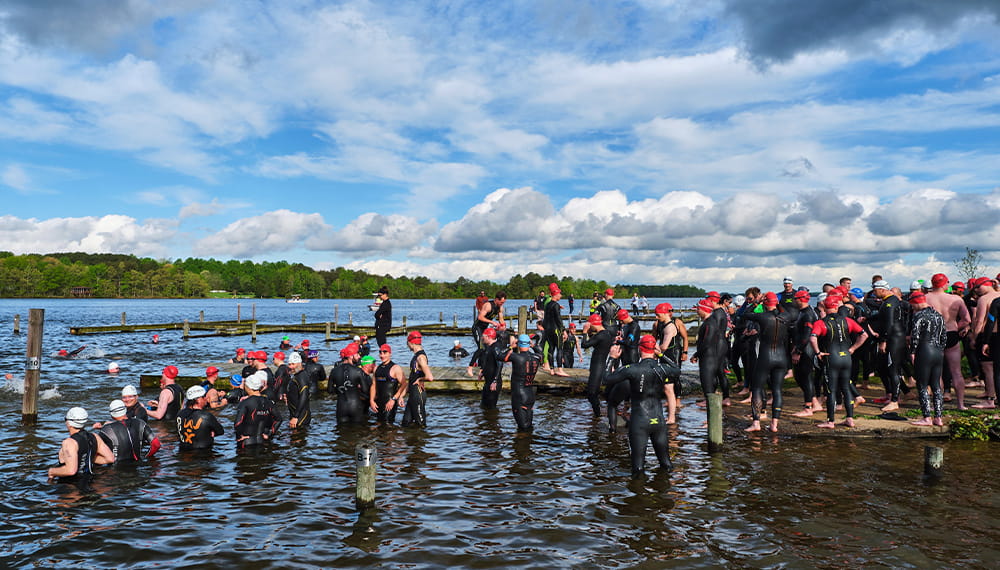 A lot of swimmer standing on shore prepare for a race