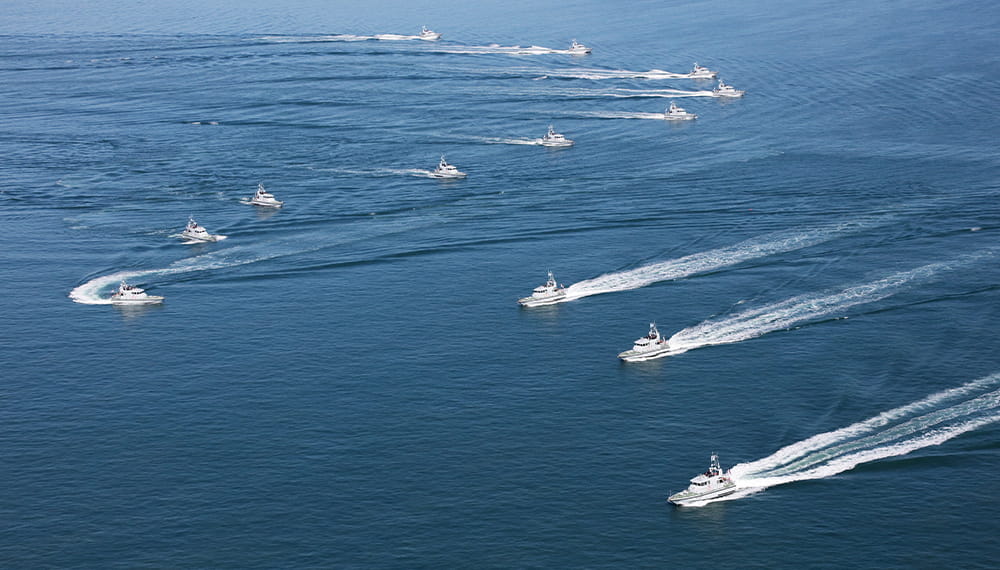 Context image of a fleet of boats on maneuver at sea