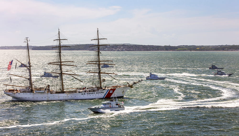 A large sailing boat being approached by a harbour patrol