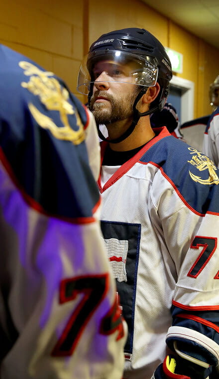 Man wearing a helmet and a number 7 ice hockey shirt