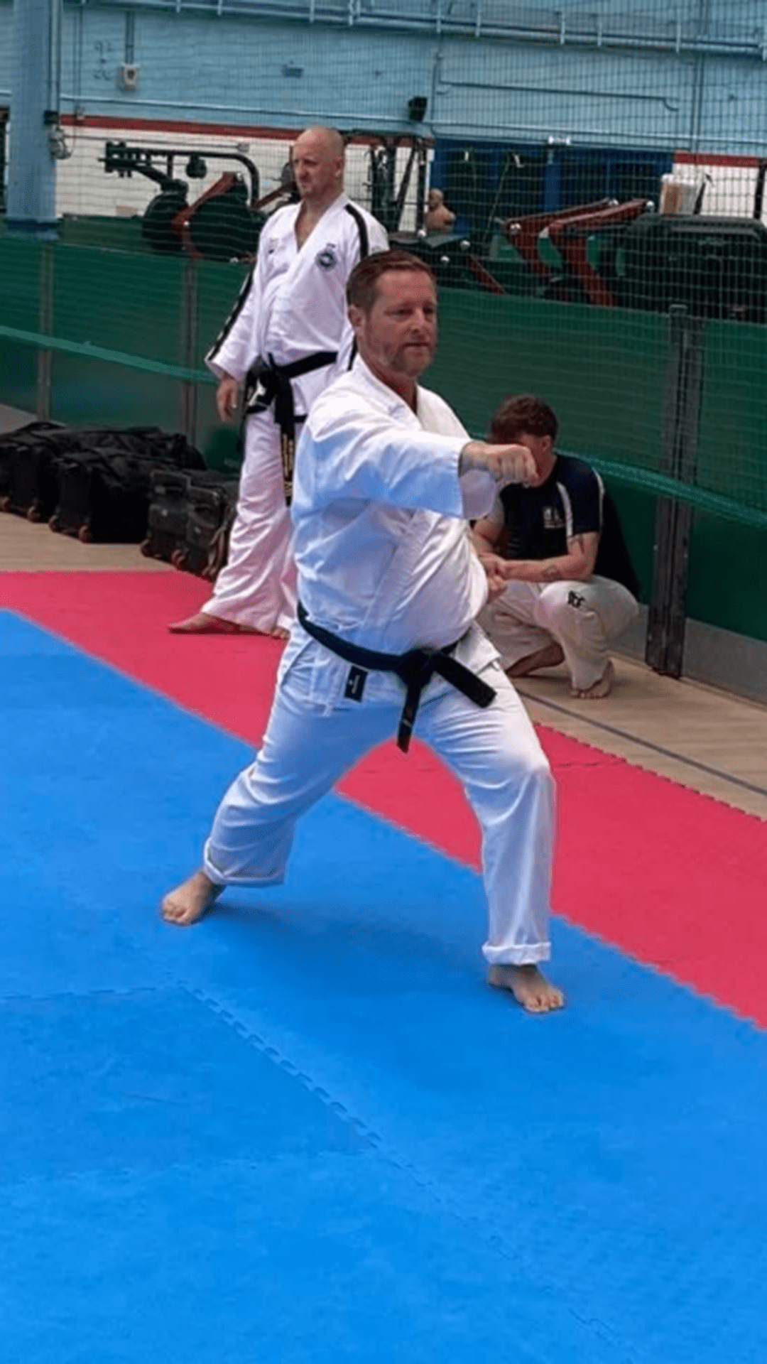 Man wearing a karate outfit and holding a fighting stance