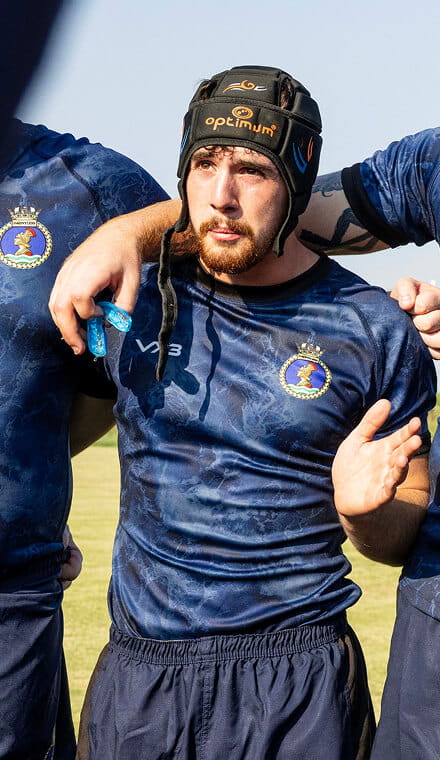 Man wearing a Rugby scrum cap and giving a team talk