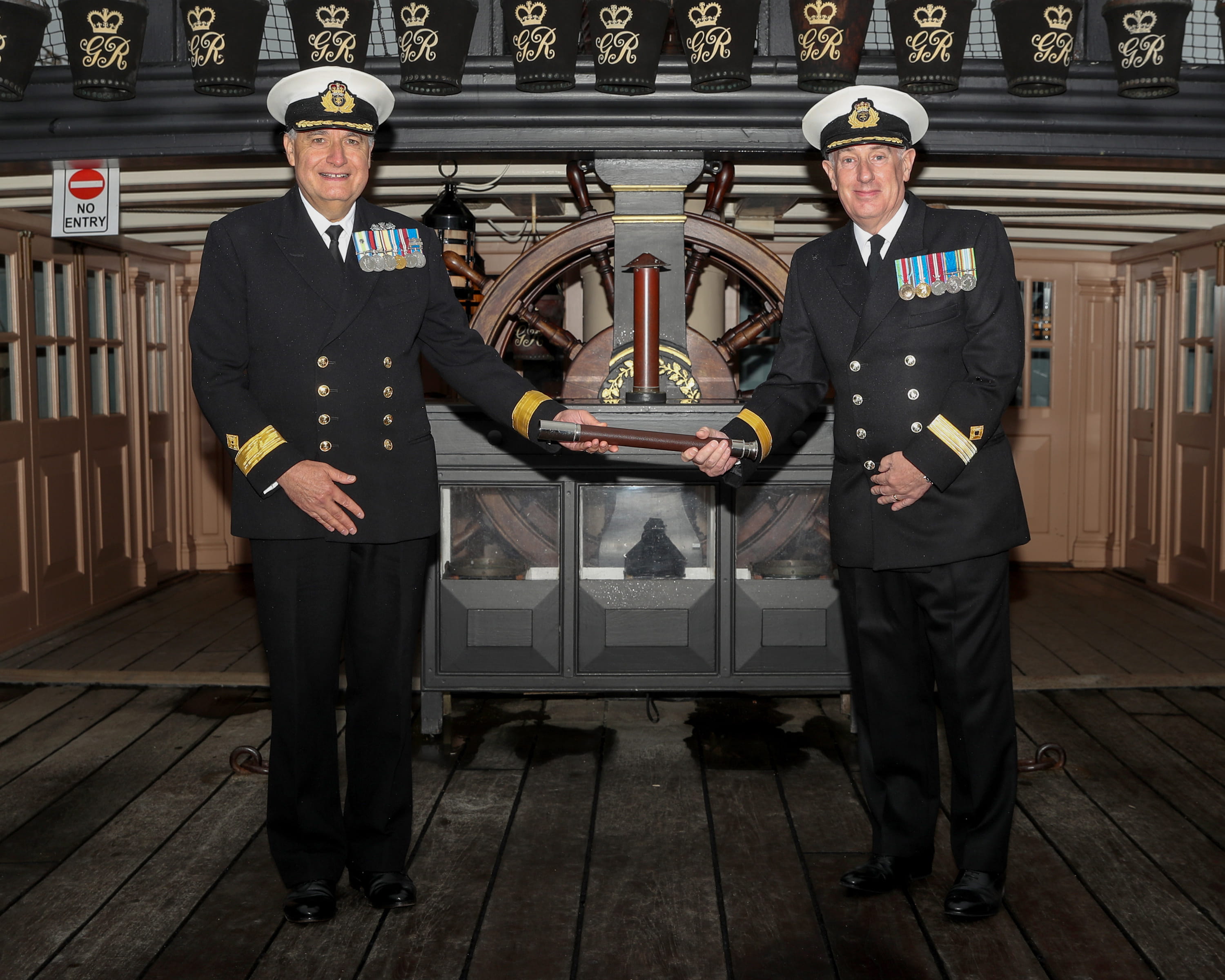 Outgoing head of the RFA Cdre Duncan Lamb (left) presents the ceremonial telescope of office to his successor Cdre David Eagles