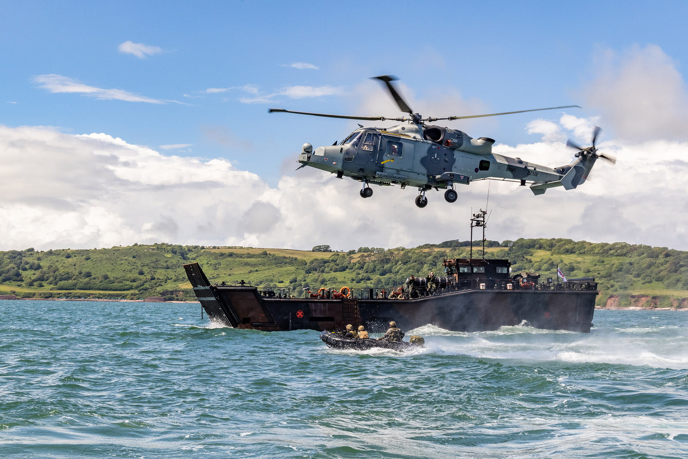 An 847 NAS Wildcat hovers over an IRC as it approaches a LCU