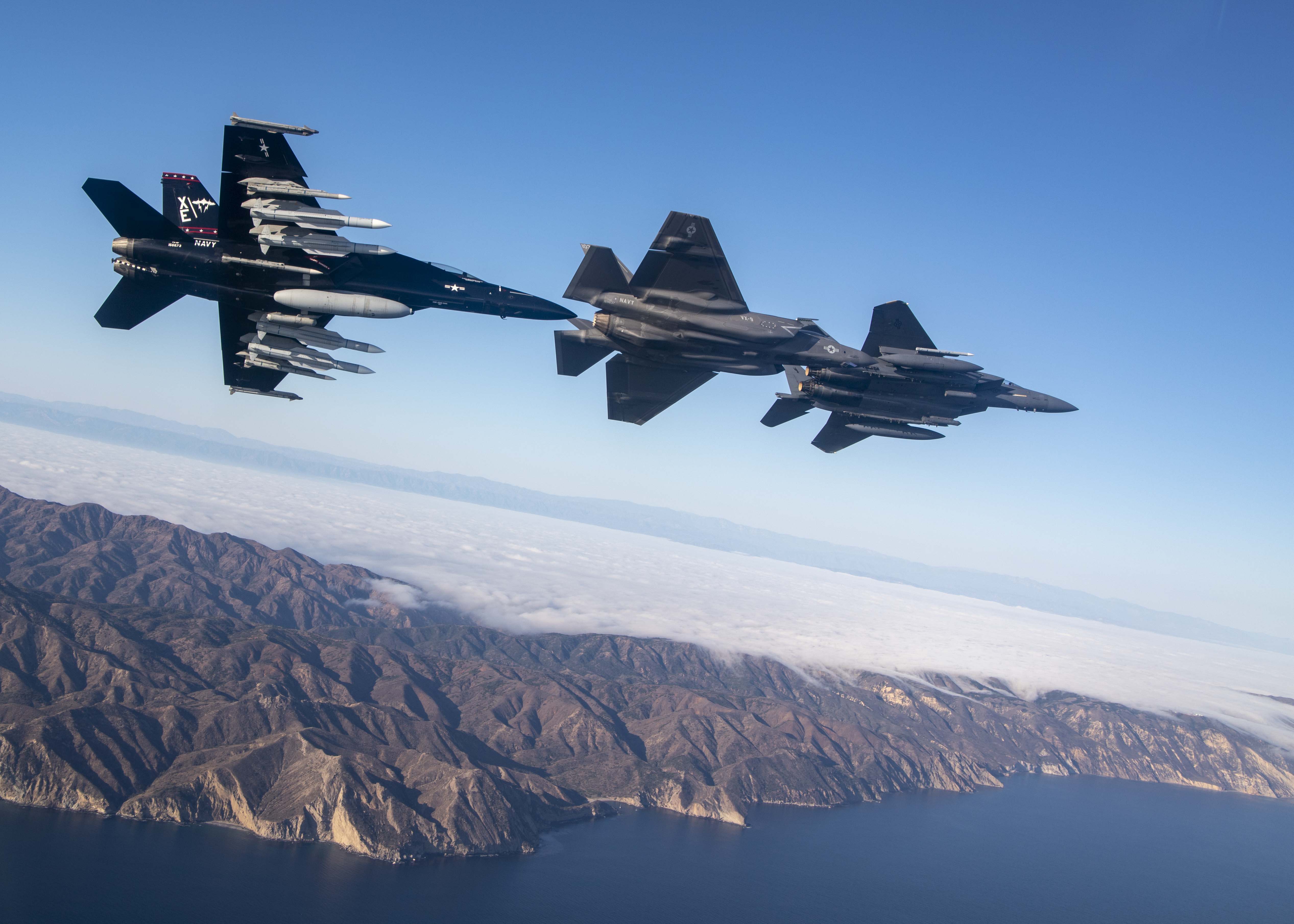 A US Navy FA-18F and F-35 fly over the Point Mugu Sea Range in southern California with a US Air Force F-15