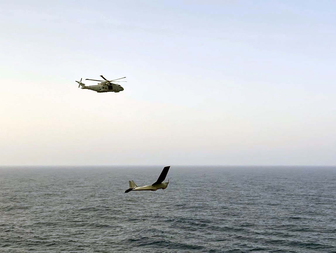A Puma flies low over the Atlantic in tandem with the Merlin