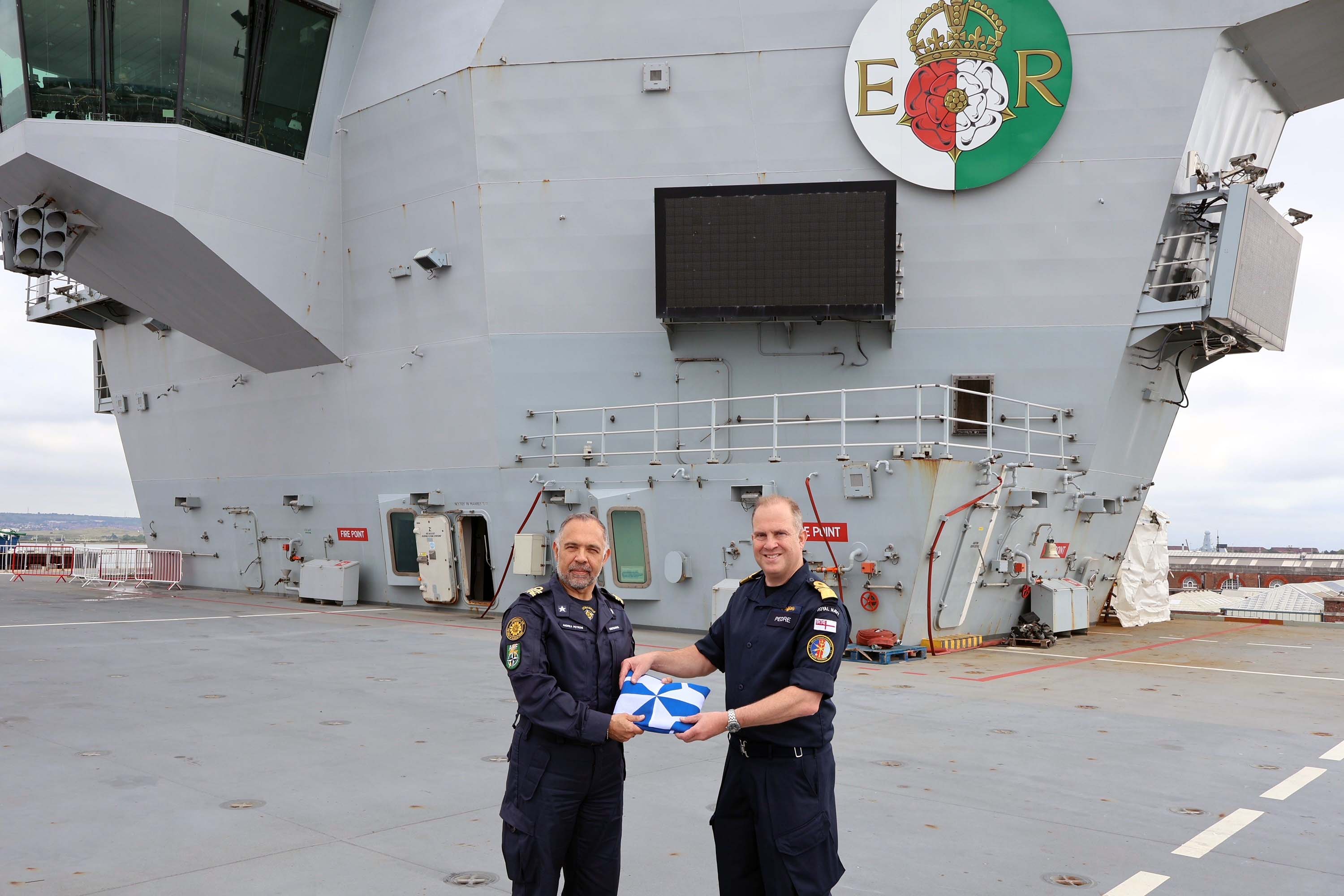 Italys Rear Admiral Andrea Petroni receives the task group standard from Rear Adm Rob Pedre