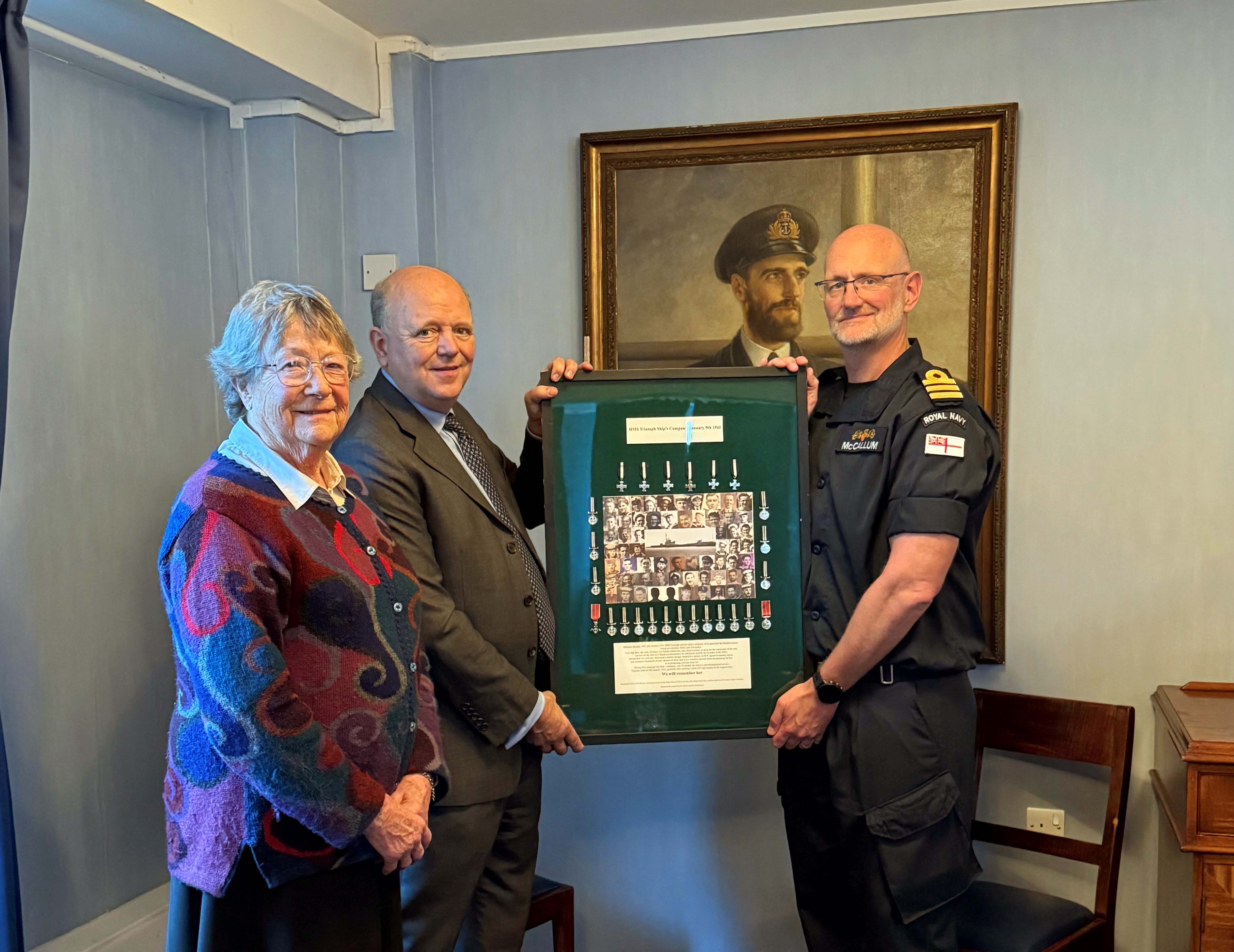 Historian Gav Don and Frances Impey niece of a Triumph crewman present the medals board to Raleigh's Cdr Malcolm McCallum