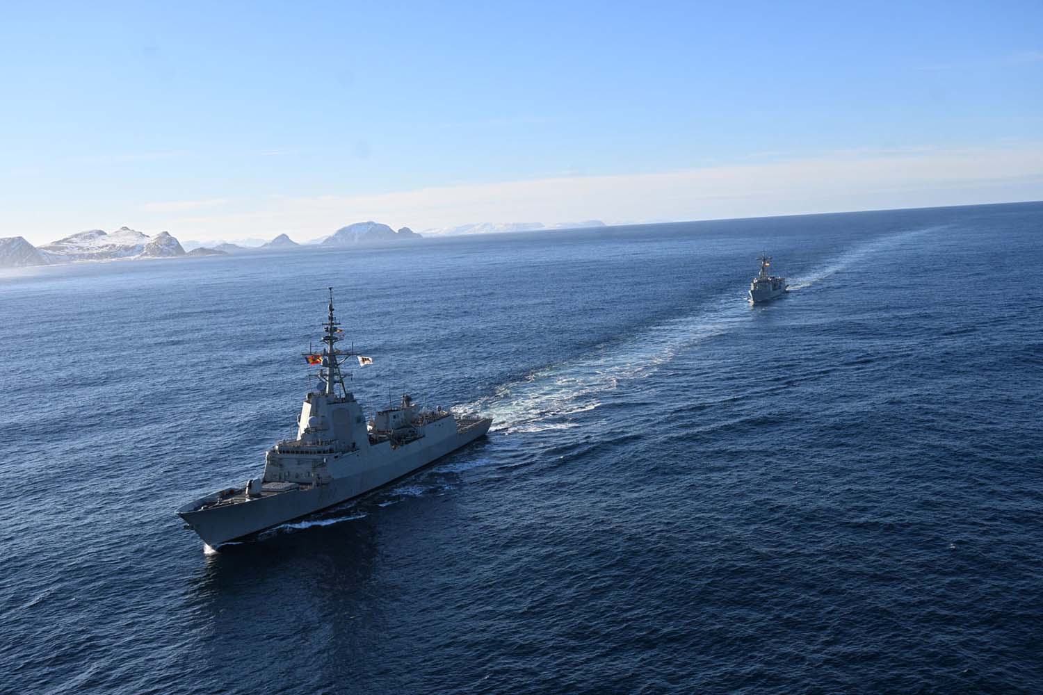 SPS Almirante Juan de Borbón silhouetted against the rugged Norwegian coastline