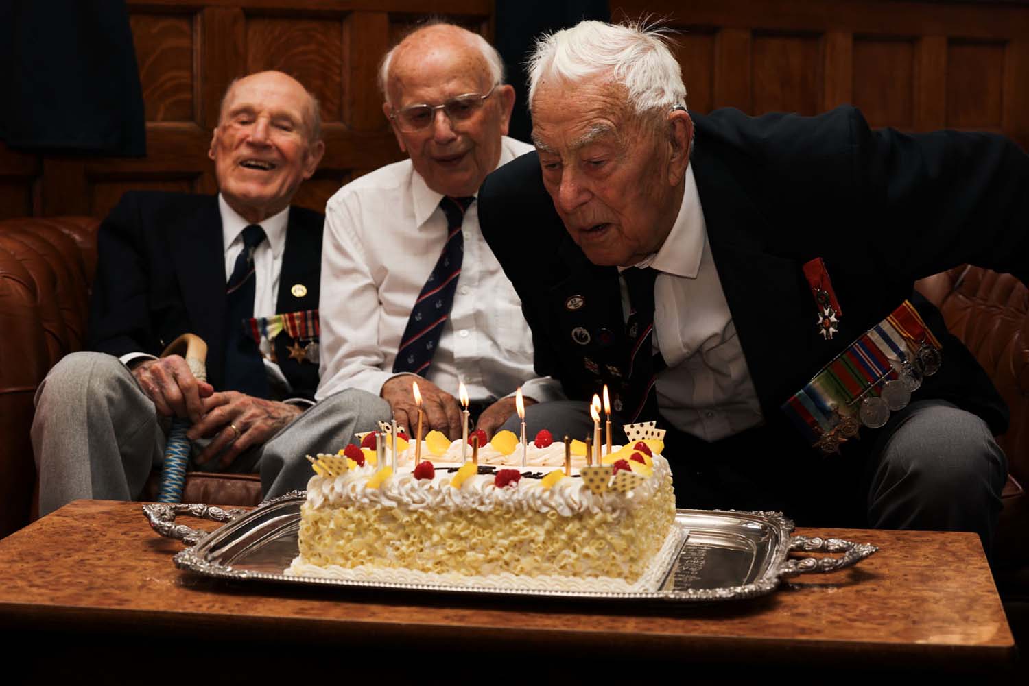 Len Chivers, Ken Arkell and Henry Rice blow out the candles on the cake