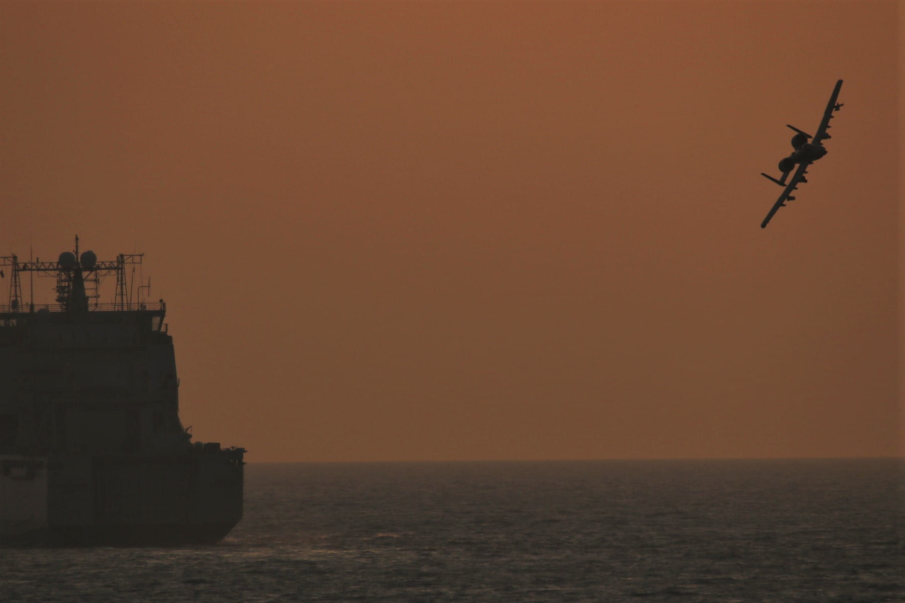 An A-10 banks off the bow of RFA Cardigan Bay