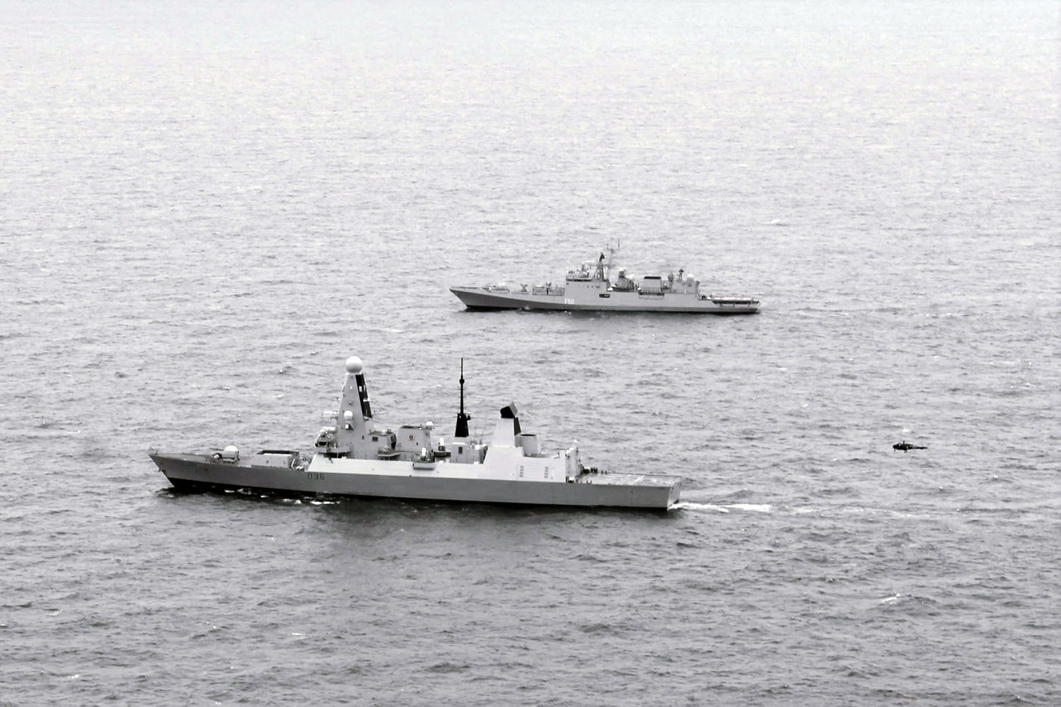 HMS Defender, nearest the camera, with Indian guided-missile frigate Tarkash in the Channel, Aug 14 2019, during Exercise Konkan. An Indian Helix helicopter can be seen approaching Defender's flight deck