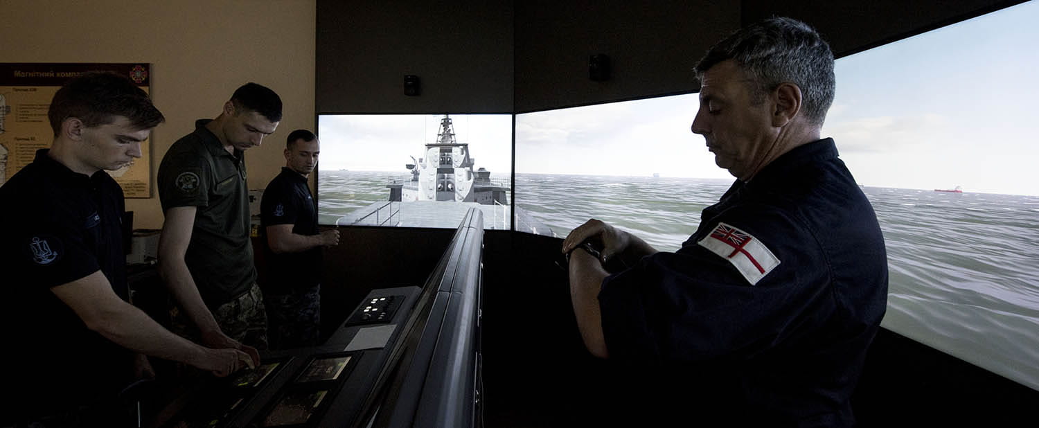 A team of specialists work with Ukrainian instructors and recruits to train them in ship navigation, firefighting, and damage repair