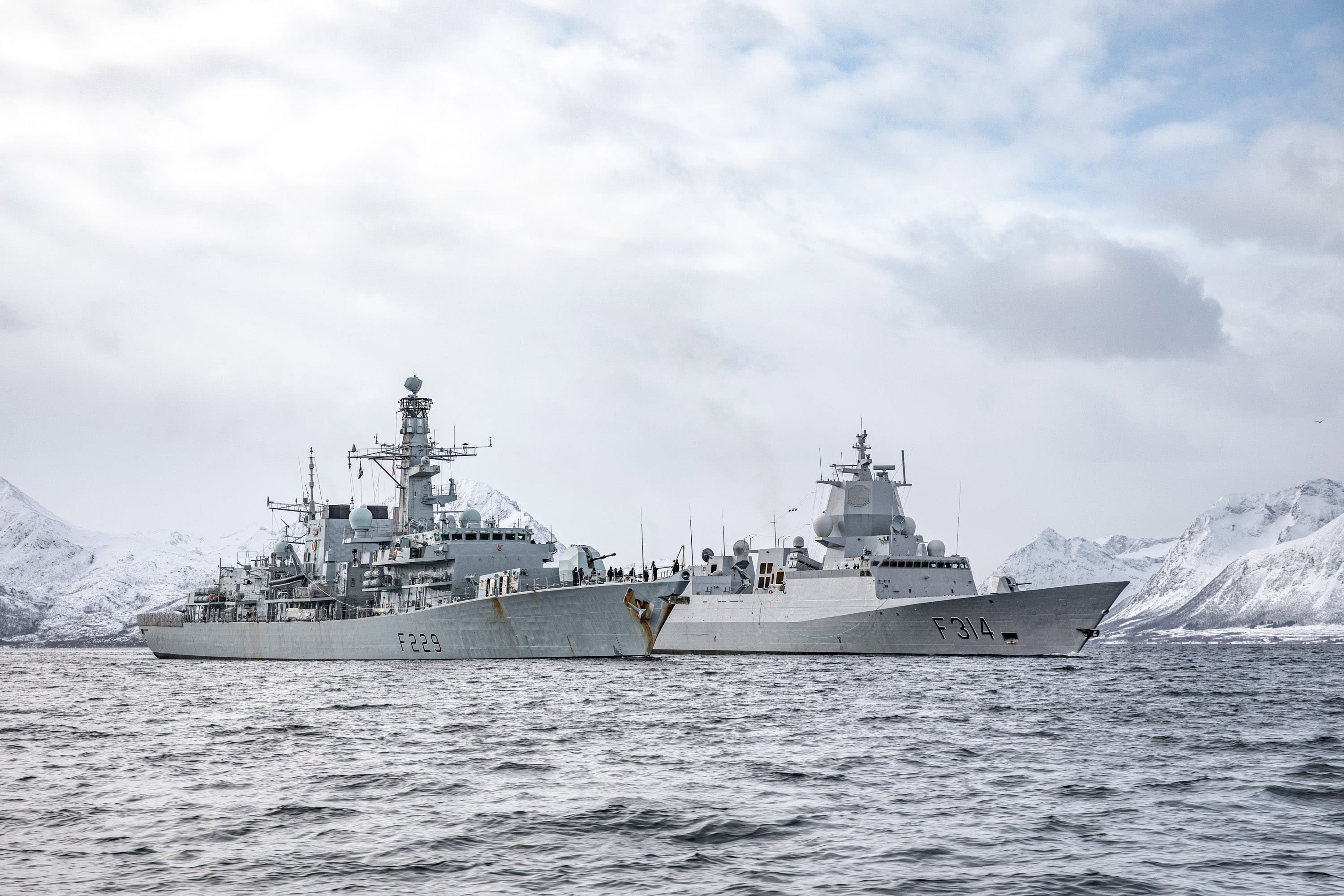 HMS Lancaster and HNoMS Thor Heyerdahl shelter from Arctic storms in a fjord