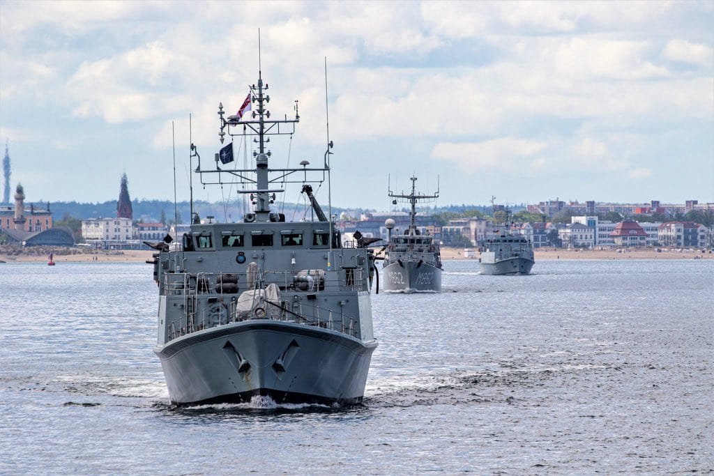 HMS Pembroke leads the way out of Warnemunde near Rostock