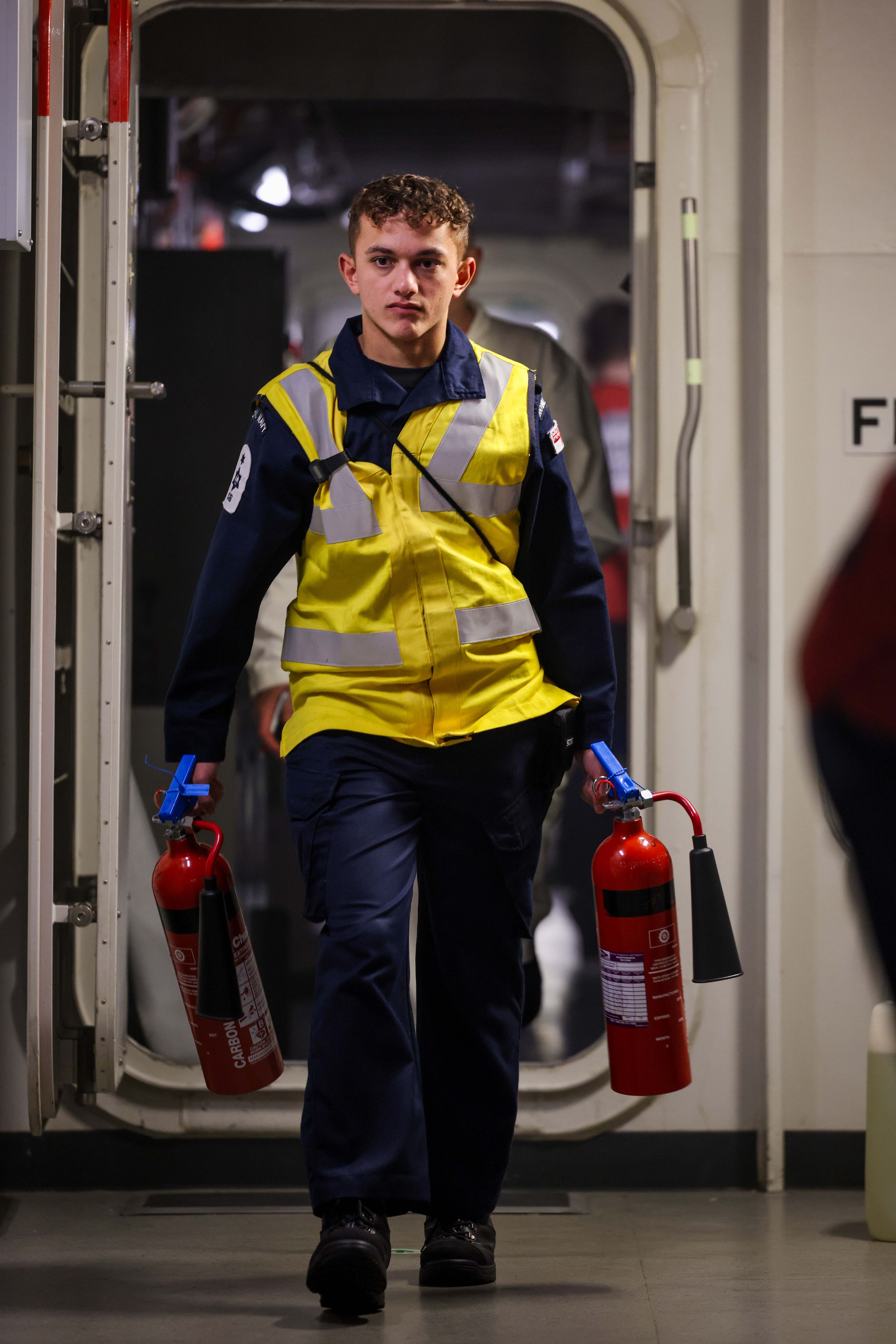 Declan carrying fire extinguishers in his secondary role with the