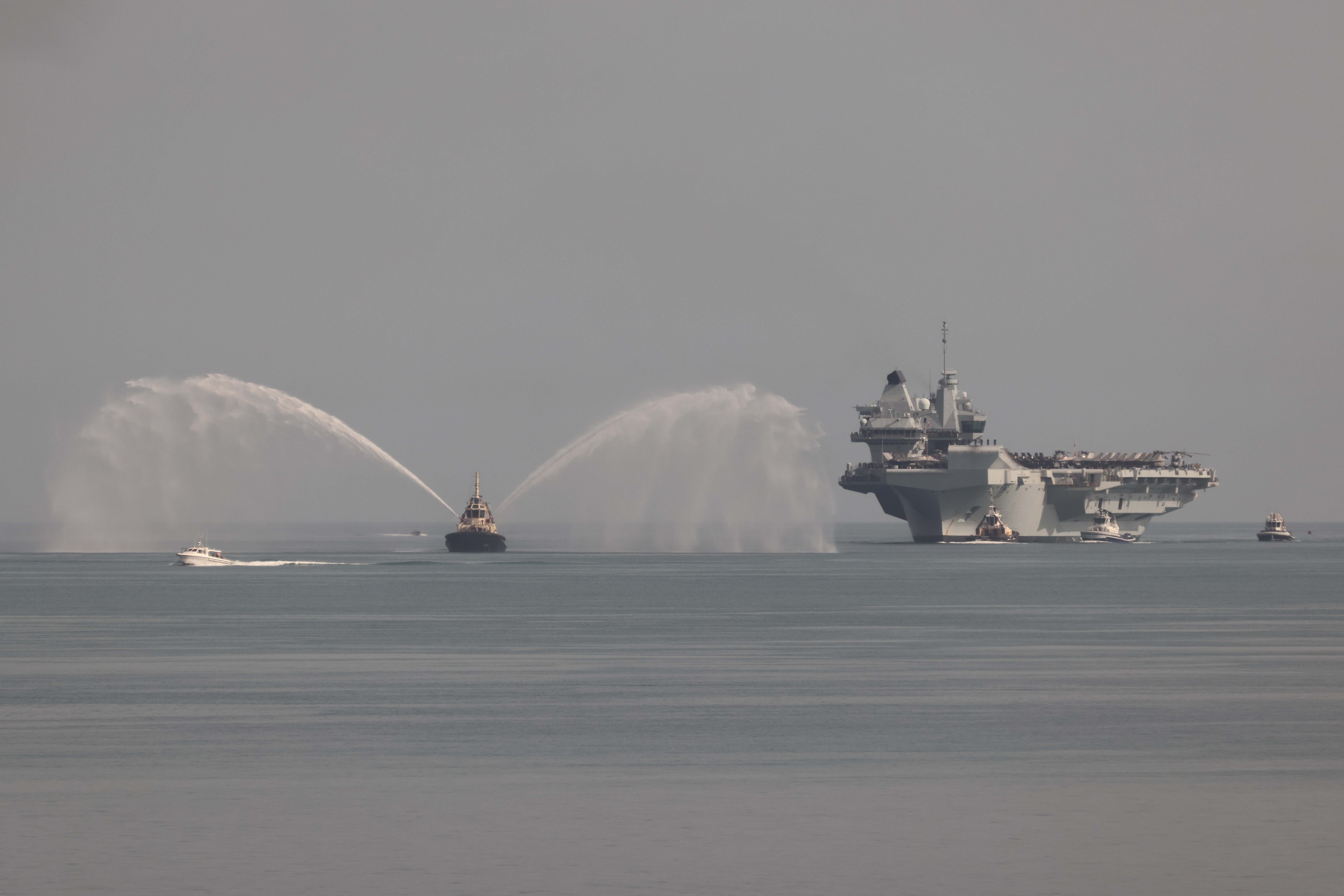 HMS Prince of Wales enters the port of Darwin and HMAS Connawarra.