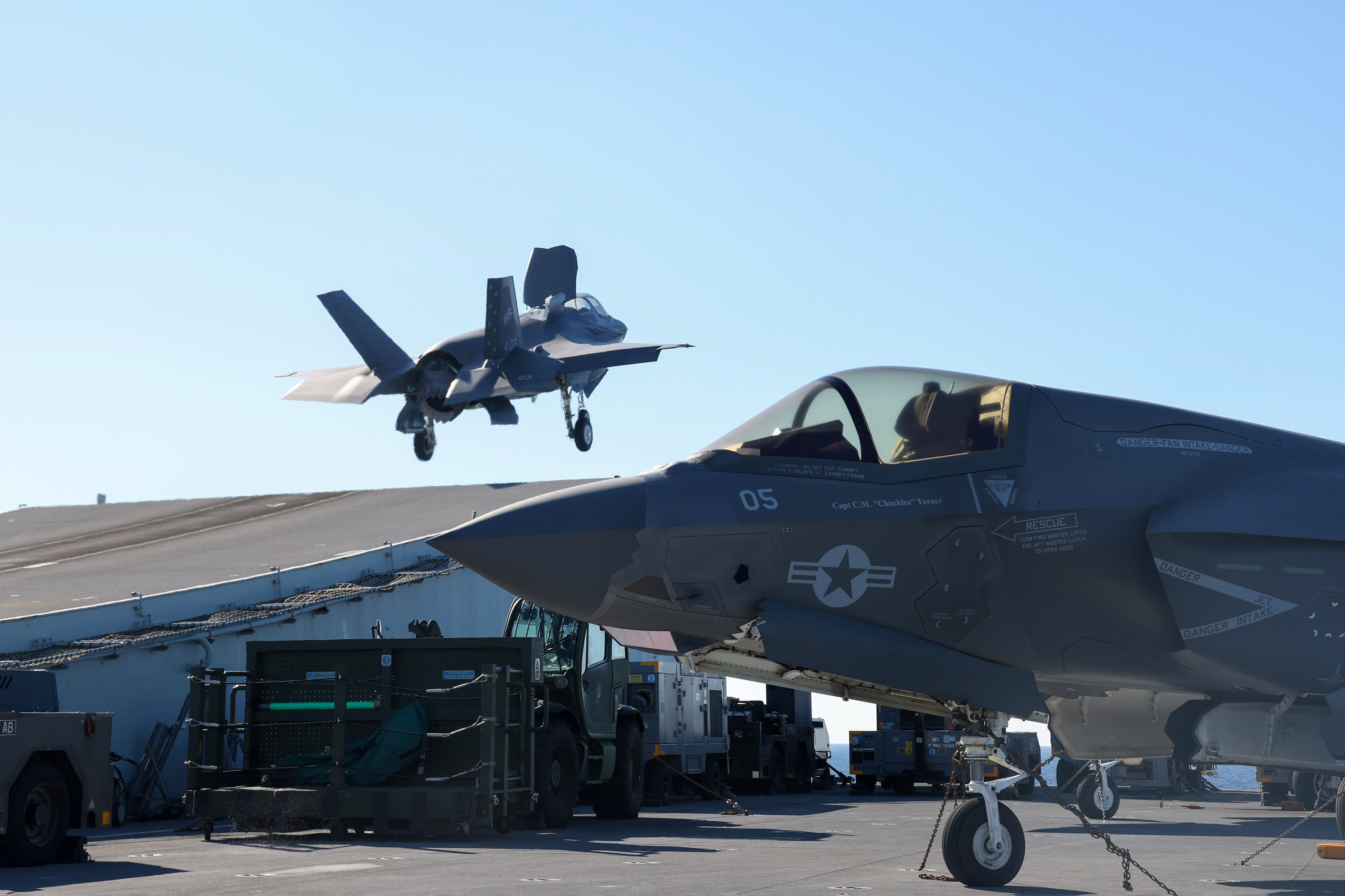 An Italian F-35 lifts of the ramp with a USMC Lightning parked in the foreground