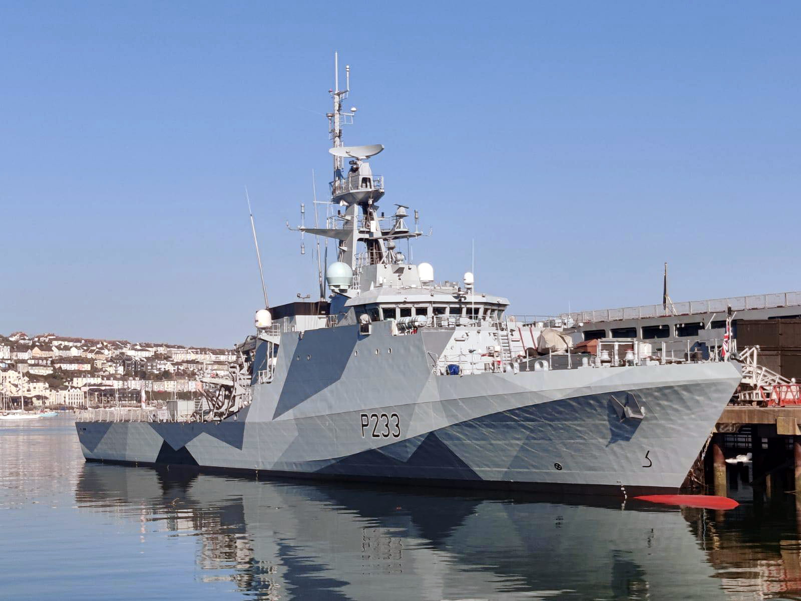 HMS Tamar with her new dazzle paint scheme in the water in Falmouth