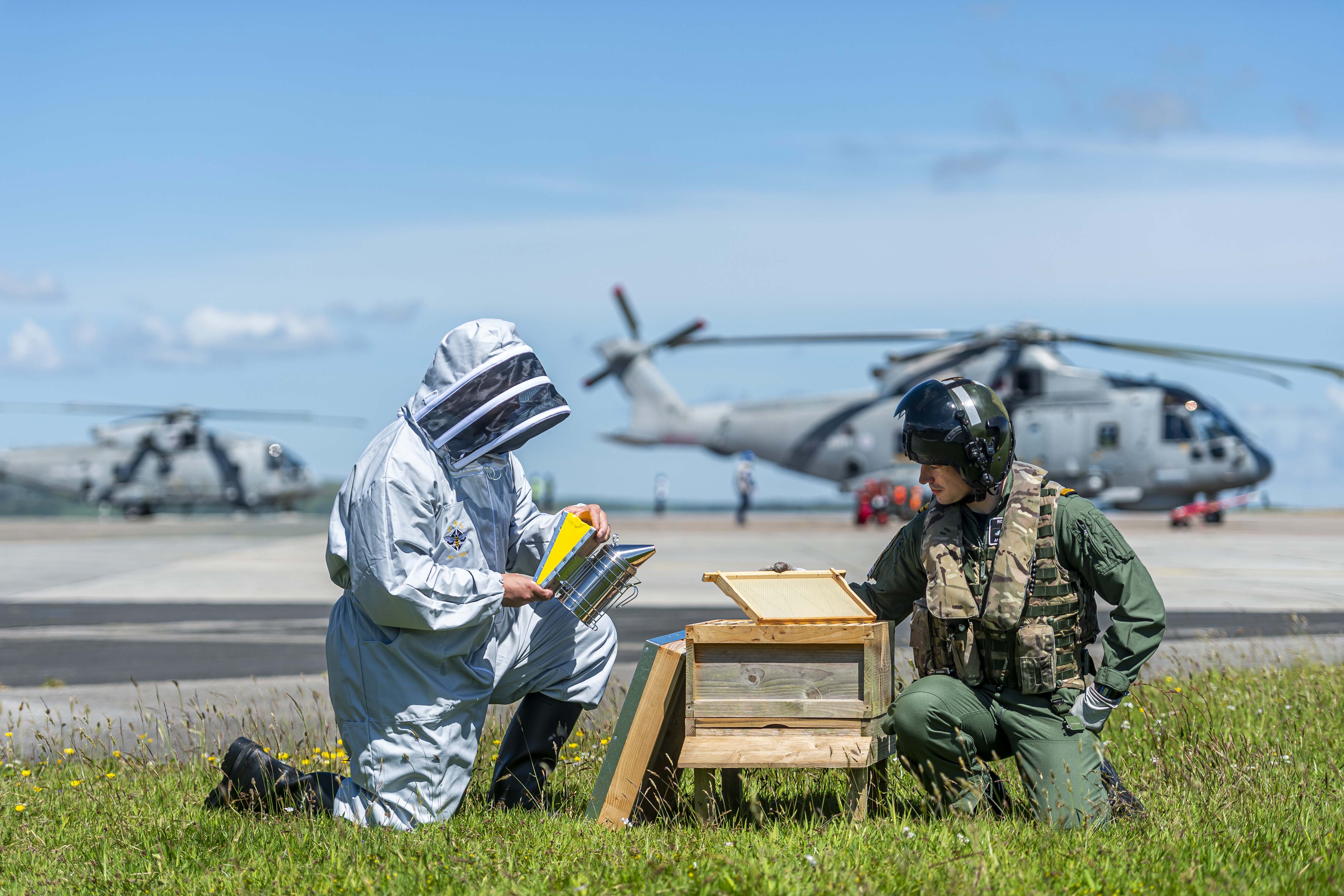 Survival Equipment Technician James Harrison (left) and Lieutenant Adam Pollock (right) inspect the beekeeping equipment.