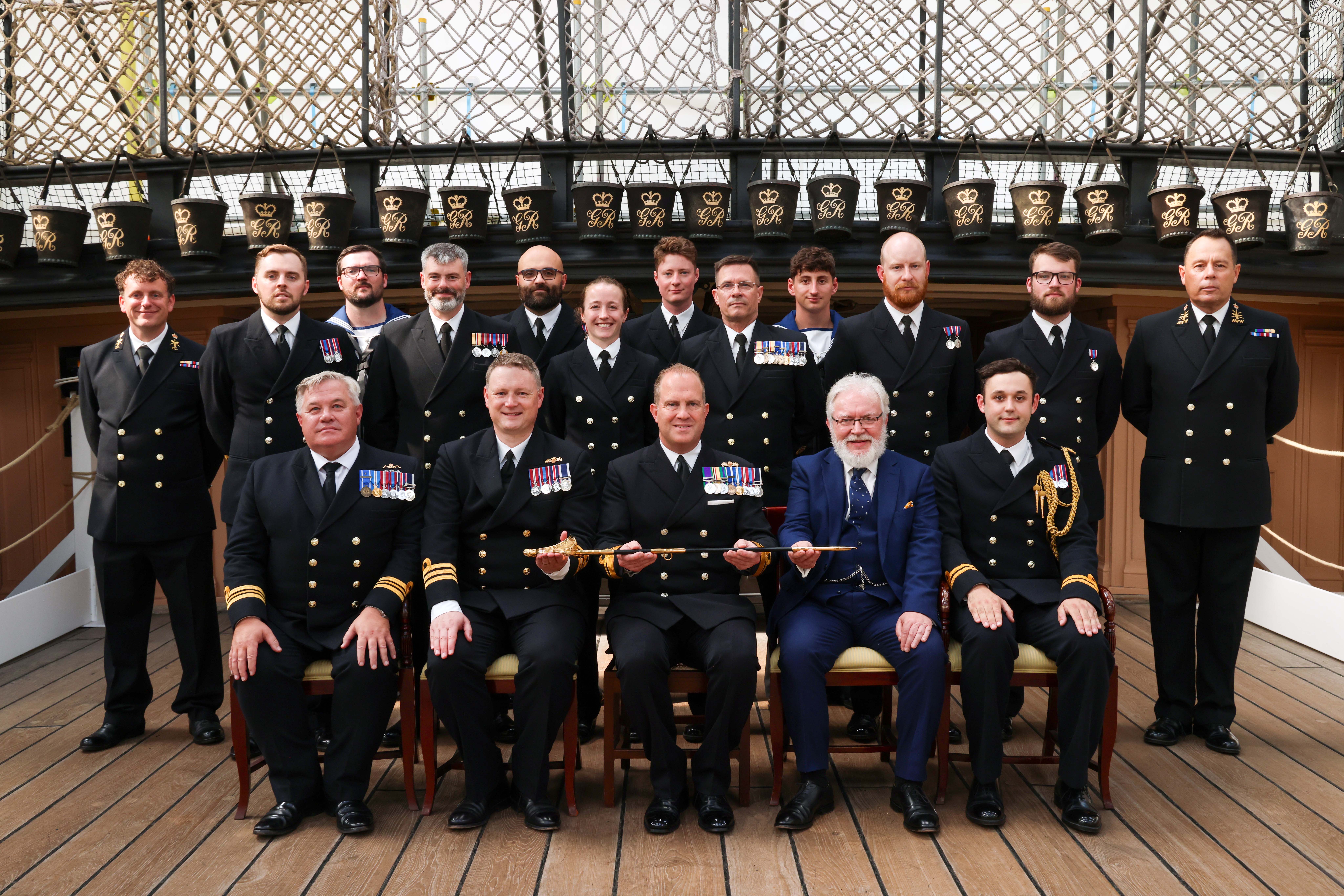Group photo of Rear Admiral Robert Pedre (Commodore UK Strike Force) with the Coastal Forces Squadron and Mr Tony Kelly.