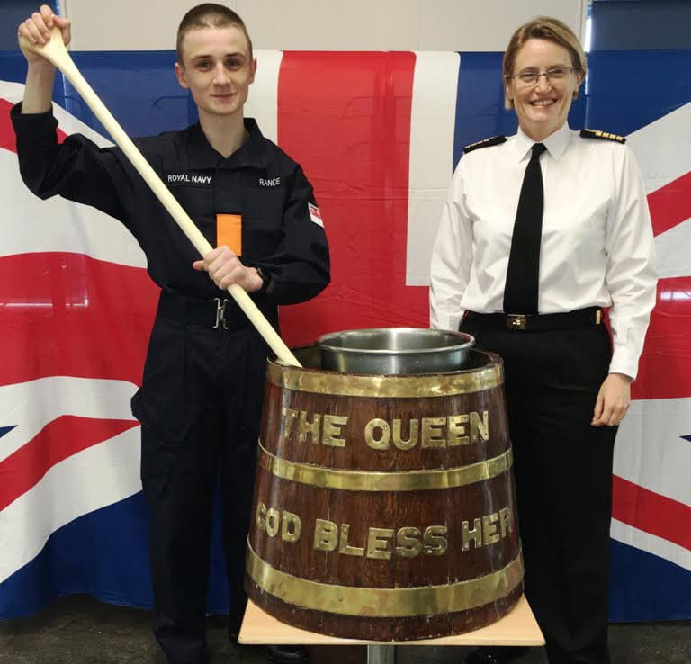 Youngest sailor and Captain stir the pud
