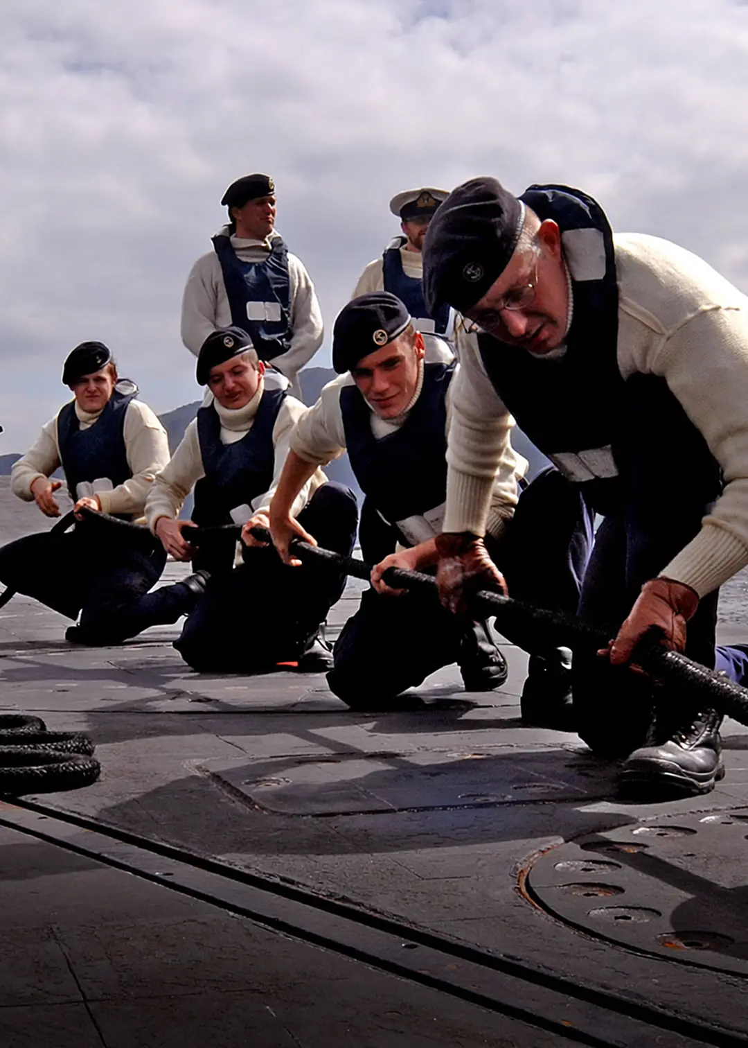 people hoisting on a submarine